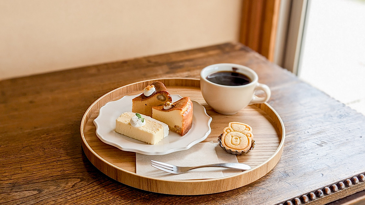 3つのケーキとコーヒーが丸盆にのせられたセット